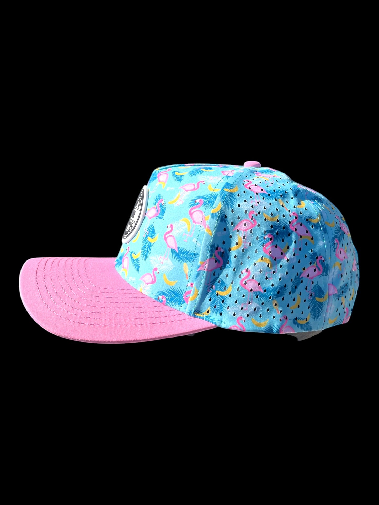 GolferBro blue performance cap with pink bill, featuring a flamingo and banana print with laser-cut perforations.