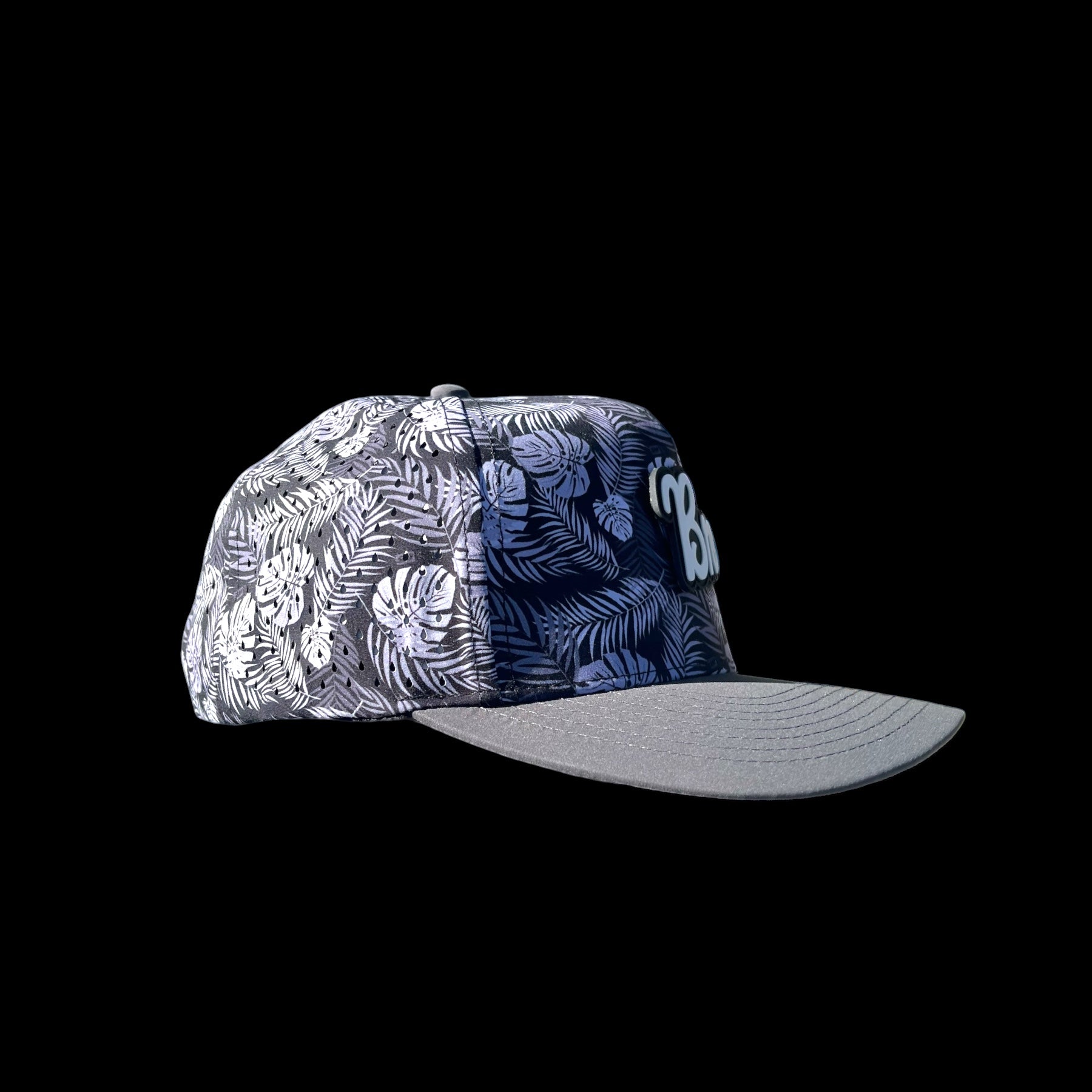 GolferBro performance snapback cap with tropical leaf print, grey bill, and perforated side panels.